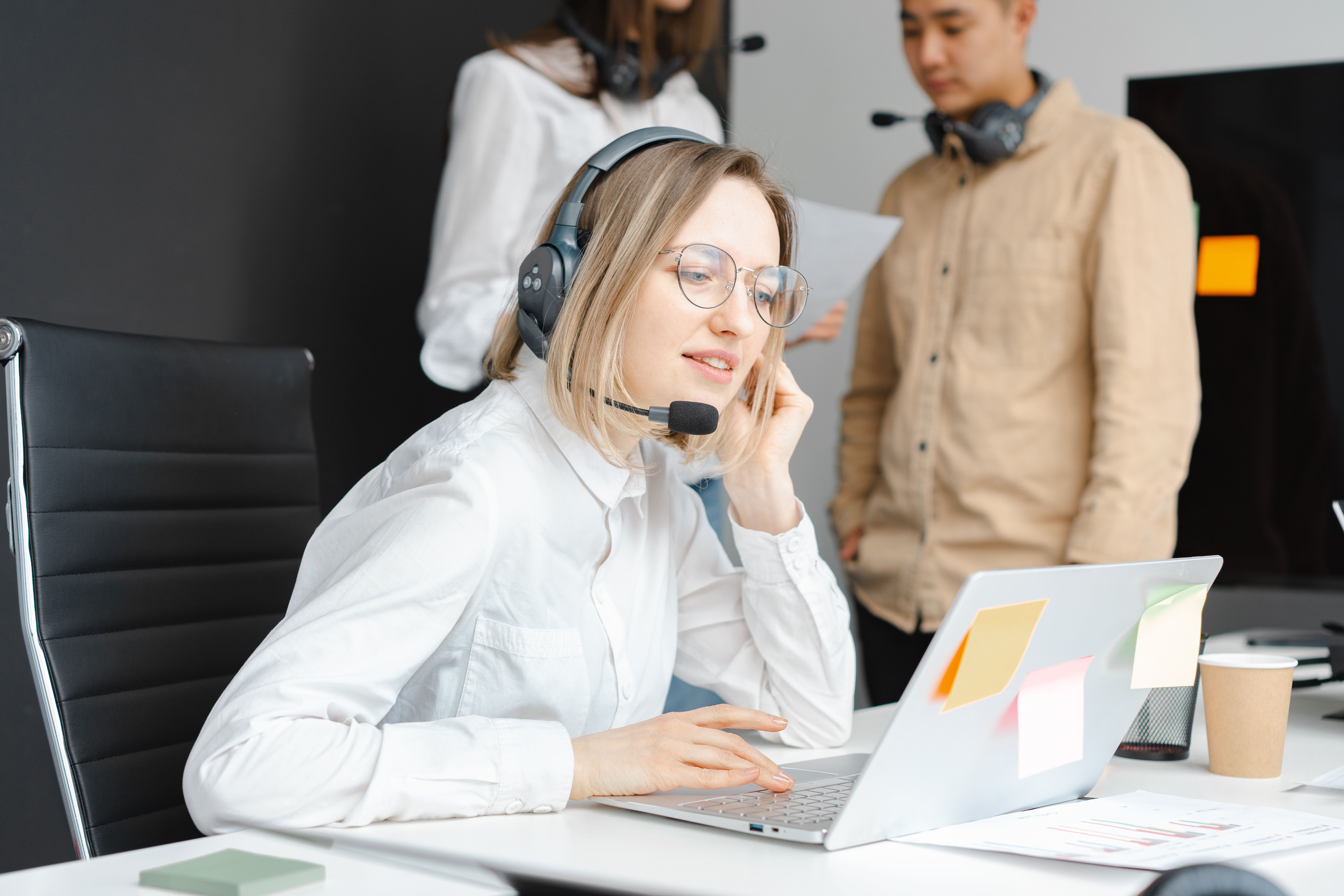 An adviser wearing a headset answering a customer from her desk